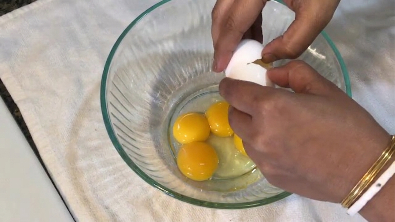 Egg yolks and one whole egg lightly whisked in a mixing bowl