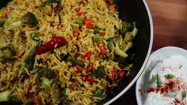Final fluffy, vibrant vegetable masala rice garnished with coriander on a plate