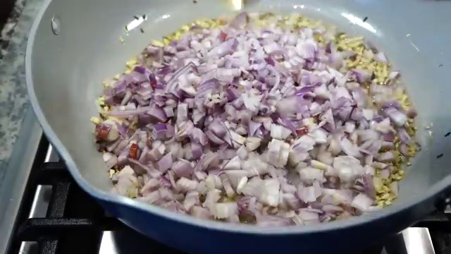 Finely chopped yellow onions added to the aromatic garlic and cumin base