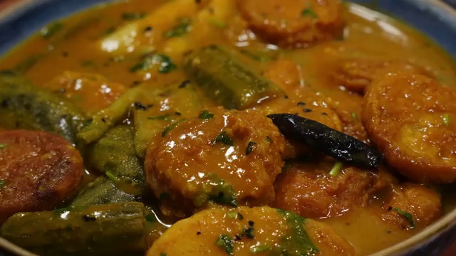 Finished Bengali Dal Bora Curry served in a bowl with tender ridge gourd, potatoes, and soft fritters