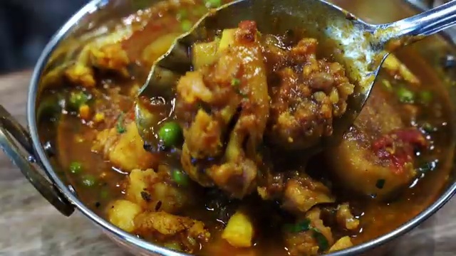 Finished Bengali aloo fulkopir tarkari garnished with coriander and green peas in the skillet