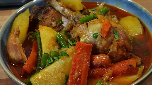 Finished Bengali-style light chicken jhol garnished and served in a bowl with golden broth
