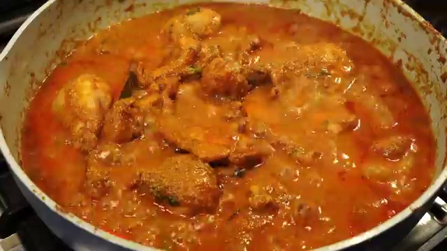 Finished Goan Chicken Xacuti served in a bowl with steamed basmati rice, warm naan, and fresh coriander