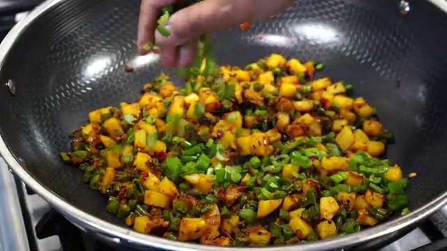 Finished aloo beans sabji garnished with freshly chopped green onion greens in the pan