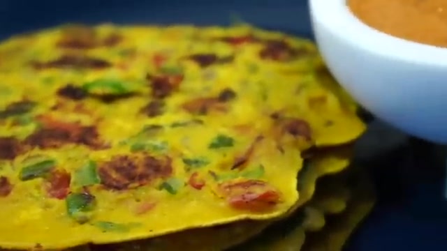 Finished vegetable besan chillas arranged on a plate with red tomato sesame chutney and fresh coriander