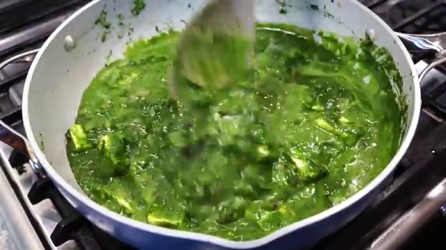 Fresh spinach leaves blanching in an open pot of boiling water for one minute