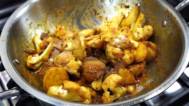 Garam masala and salt added to the cauliflower and potato curry