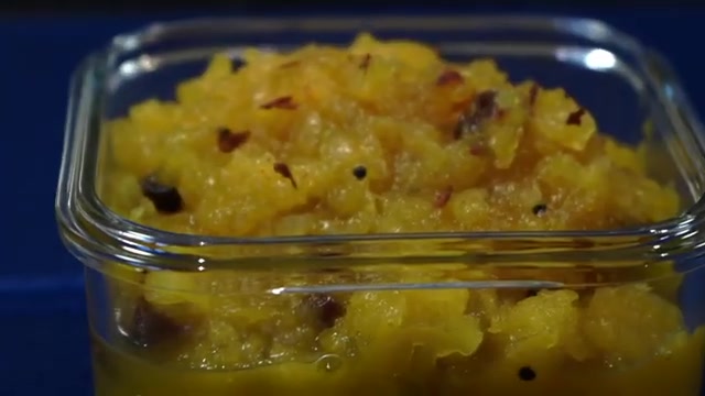 Glossy sweet pineapple chutney in a bowl, showing small pineapple pieces and raisins
