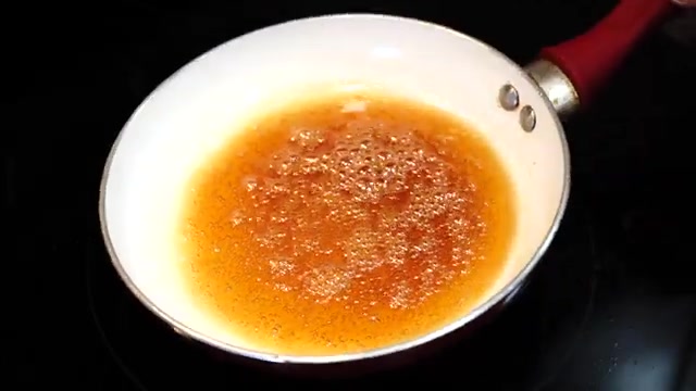 Golden-brown caramel reaching the ideal medium-brown color in a saucepan