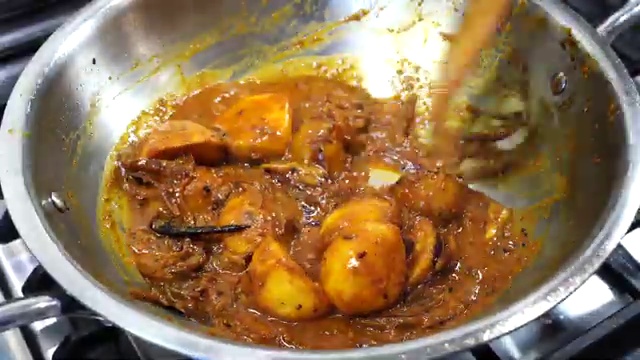 Golden-fried cauliflower florets added to the pan with the potatoes and curry base