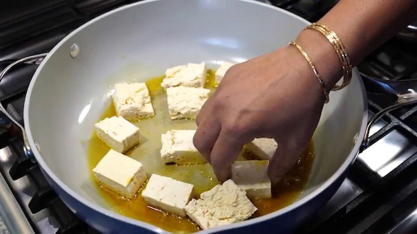 Pan-fried tofu cubes displaying a golden-brown crispy exterior and tender center