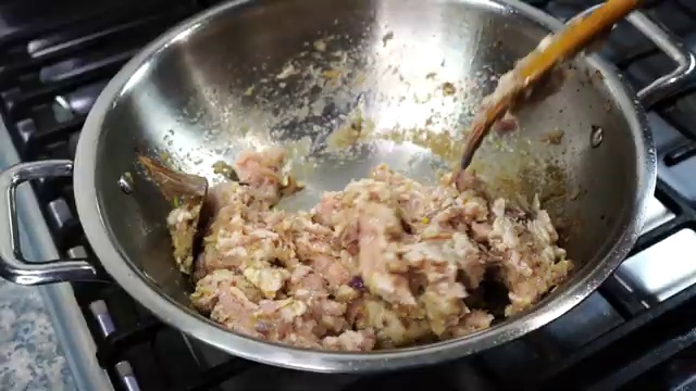 Fresh ground chicken added to the skillet with cooked onions, ginger, and garlic