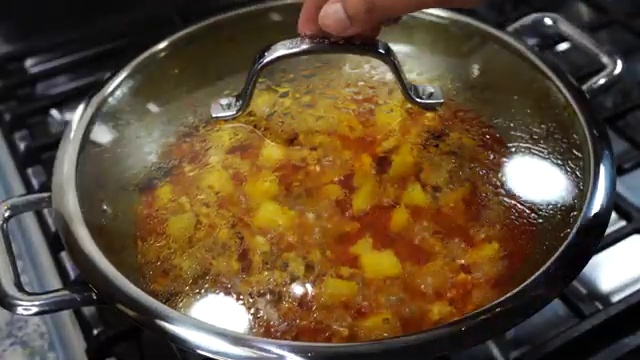 Hot water poured into the skillet to loosen the curry and create a rich gravy