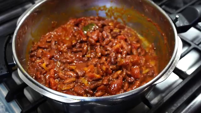 Three cups of hot water poured into the pressure cooker with the spiced kidney beans
