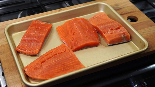 Vibrant red Kashmiri chili powder sprinkled over lemon-soaked salmon fillets