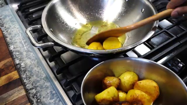 Large cauliflower florets frying in hot oil to develop a light golden crust