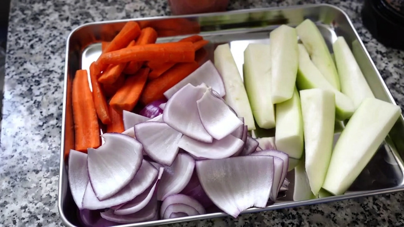 Large chunky cuts of peeled potatoes, orange carrots, and firm green papaya