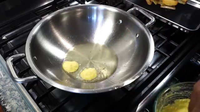 Chana dal fritters (dal bora) frying in a single layer in the hot skillet