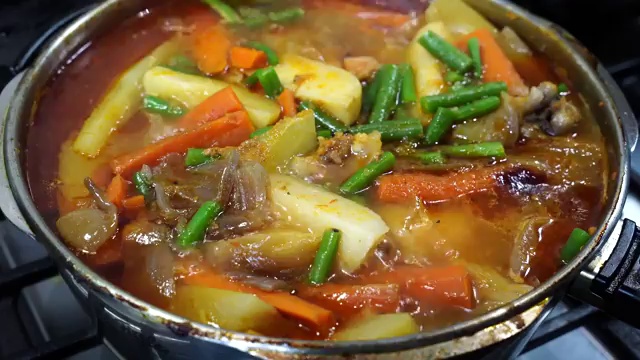 Light Bengali chicken jhol bubbling gently with tender chicken, potatoes, and vegetables