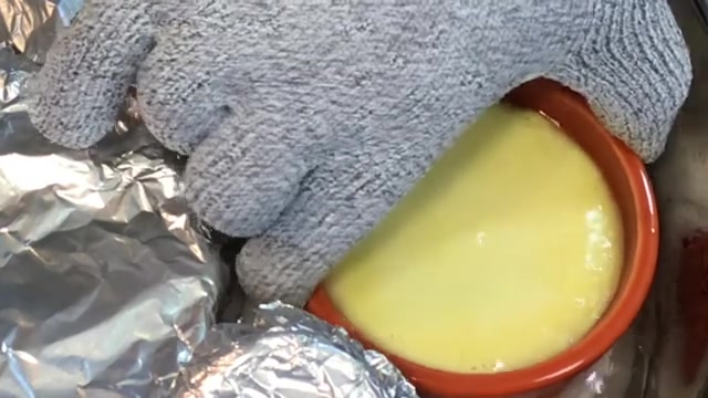 Mango crème caramel gently steaming in a covered water bath