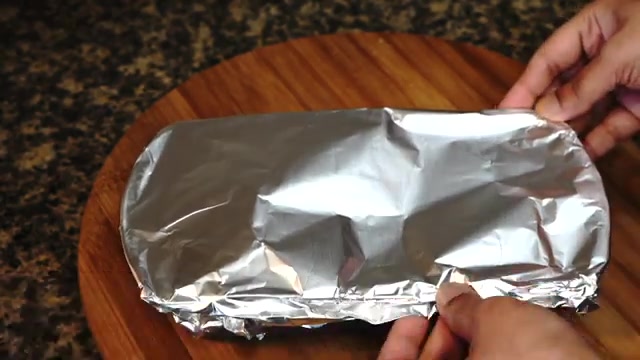 Mango custard container tightly covered with aluminum foil and ready for steaming