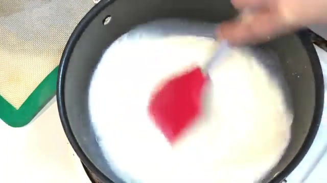 Milk gently heating in a saucepan with sugar for mango custard