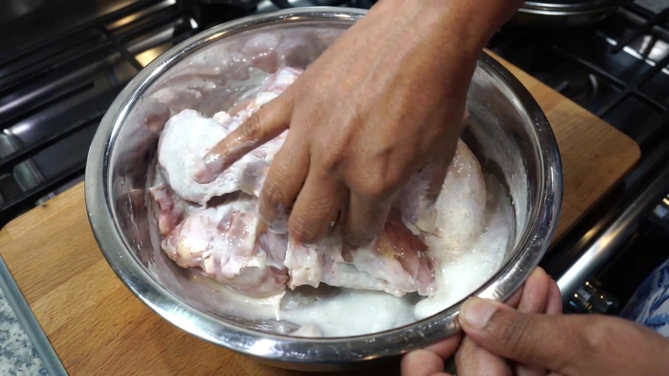Plain whole-milk yogurt and cold water being whisked together in a bowl as a buttermilk substitute
