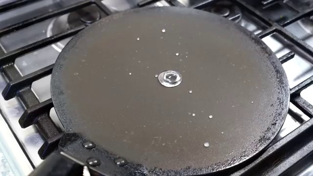 Moong dal chilla cooking over medium heat until the golden edges naturally release from the pan