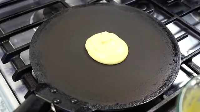 Moong dal chilla flipped to cook the golden-spotted second side for a few seconds