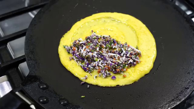 Crispy golden moong dal chilla folded in half over the colorful vegetable and paneer filling