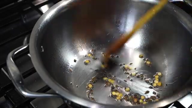 Mustard seeds, cumin seeds, and chana dal frying in oil