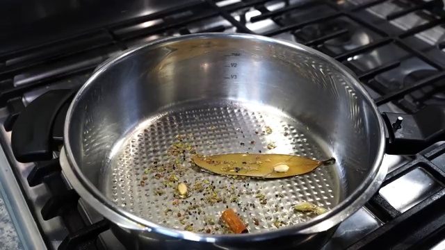 Freshly blended onion and tomato puree poured into the blooming whole spices in the pot