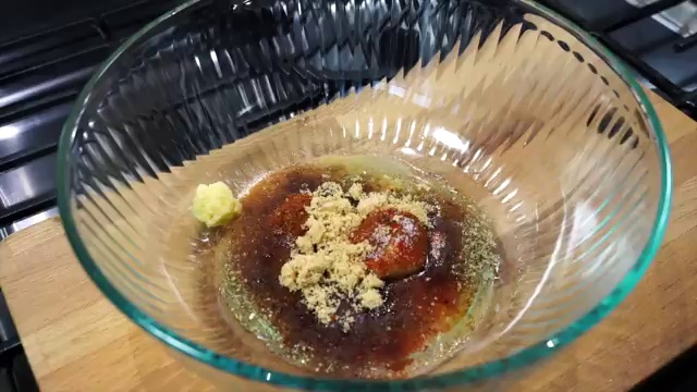Drained chicken pieces placed into the bowl of second spiced herb marinade