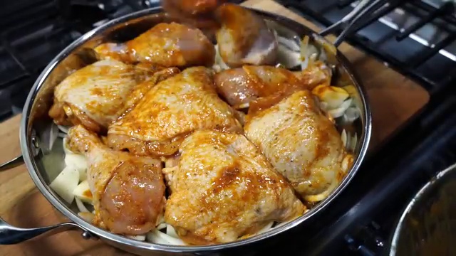 Baking tray with buttermilk chicken, potatoes, and onions placed into preheated oven