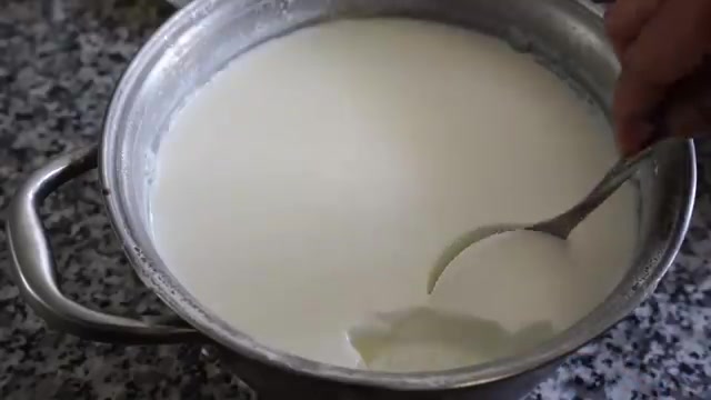 Plain yogurt being mixed into the besan and spice mixture