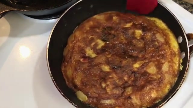 Potato omelette carefully slid back into the frying pan after being flipped