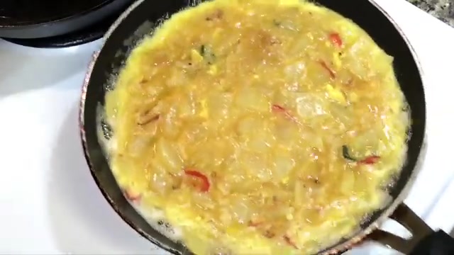 Potato, onion, and egg mixture resting in a bowl before cooking the omelette