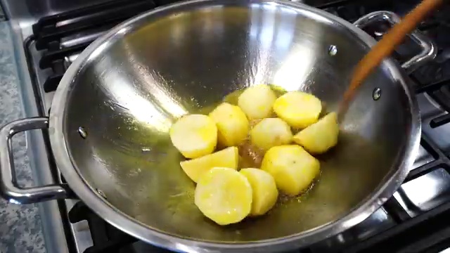 Potatoes frying over medium heat until developing golden-brown blistered edges