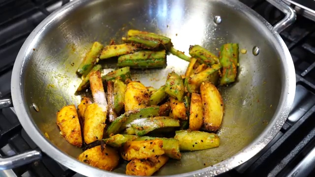 Reserved chana dal starch water poured over the spiced vegetables in the pan