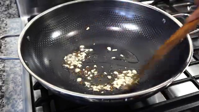 Roughly chopped garlic cloves gently browning in oil with toasted cumin and mustard seeds