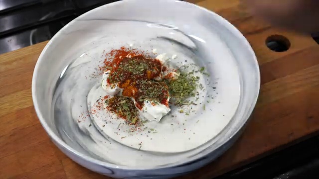 Salmon fillet being generously coated with the thick tandoori yogurt marinade