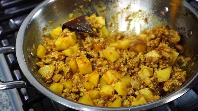 Salt added to season the spiced chicken keema curry in the pan