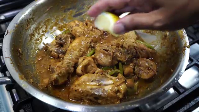 Black pepper chicken served hot in a bowl alongside warm naan bread and steamed rice