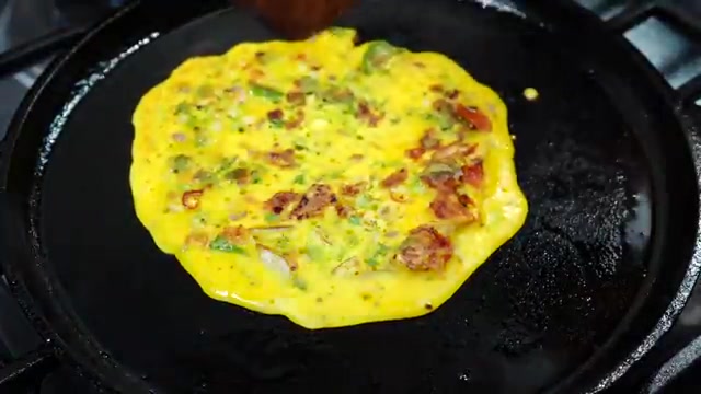 Several golden vegetable besan chillas stacked on a serving plate