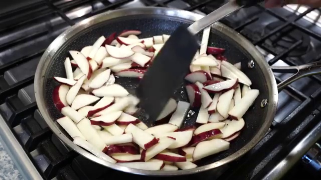 Sliced yellow onions and chopped garlic cloves added to the spiced potatoes