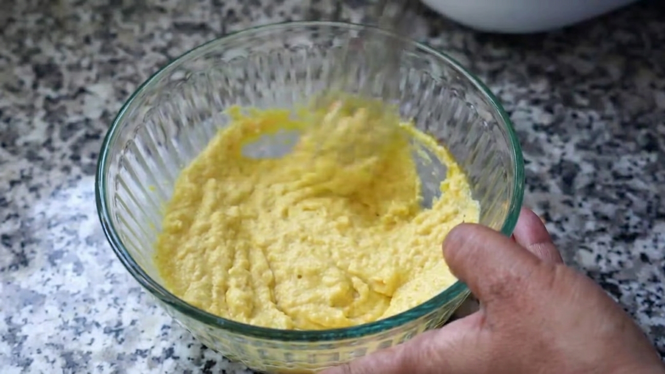 Small spoonfuls of aerated chana dal batter being dropped carefully into hot oil
