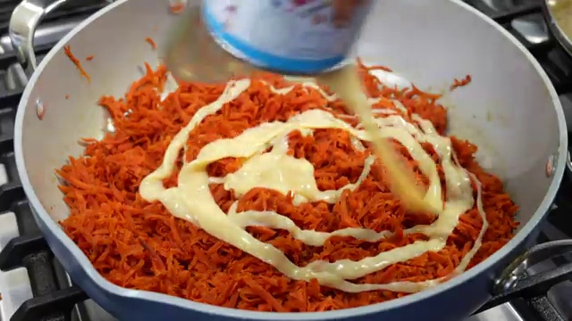 Tender grated carrots slowly absorbing whole milk and condensed milk while simmering