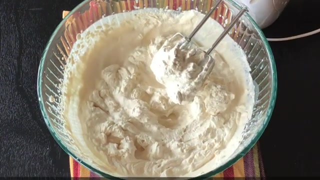 Soft whipped coffee cream being gently folded into cooled coffee custard