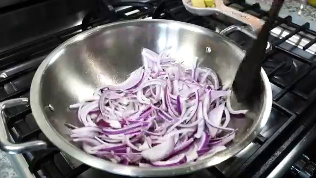 Sliced onions frying gently and turning golden brown over medium-low heat