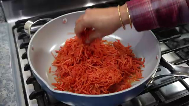 Sweetened condensed milk being poured over sautéed grated carrots